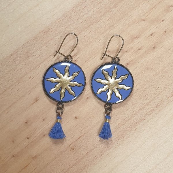 Boucles d'oreille pendantes soleil dor&eacute; sur fond bleu
