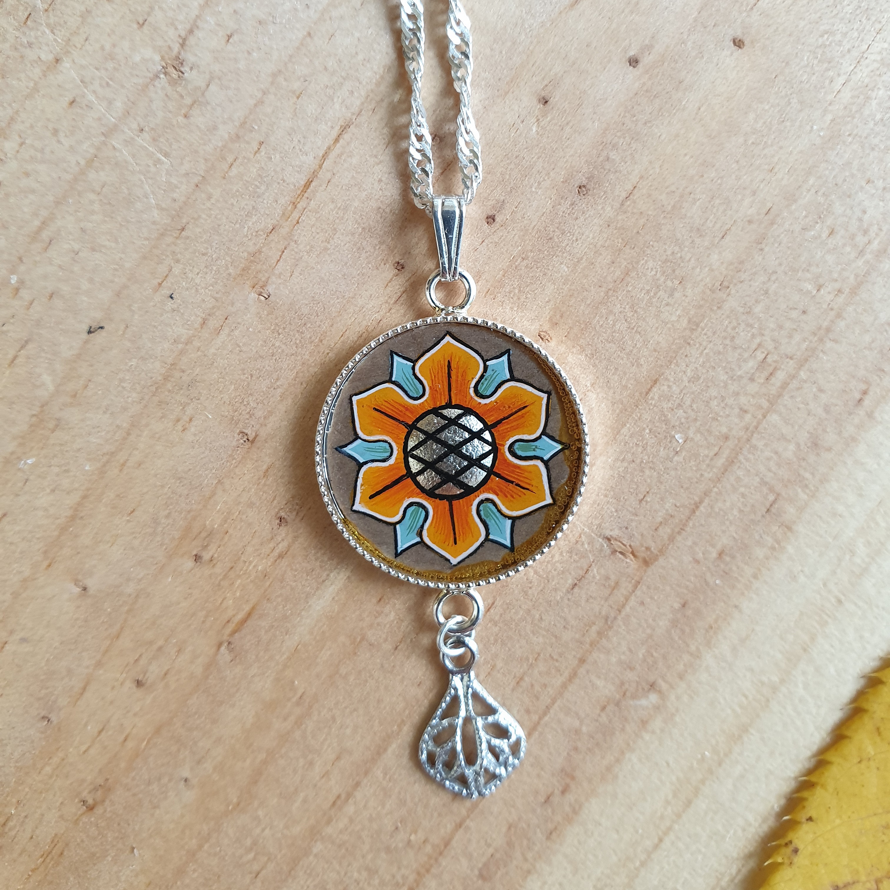 Pendentif artisanal CB Enluminures avec motif floral médiéval peint.