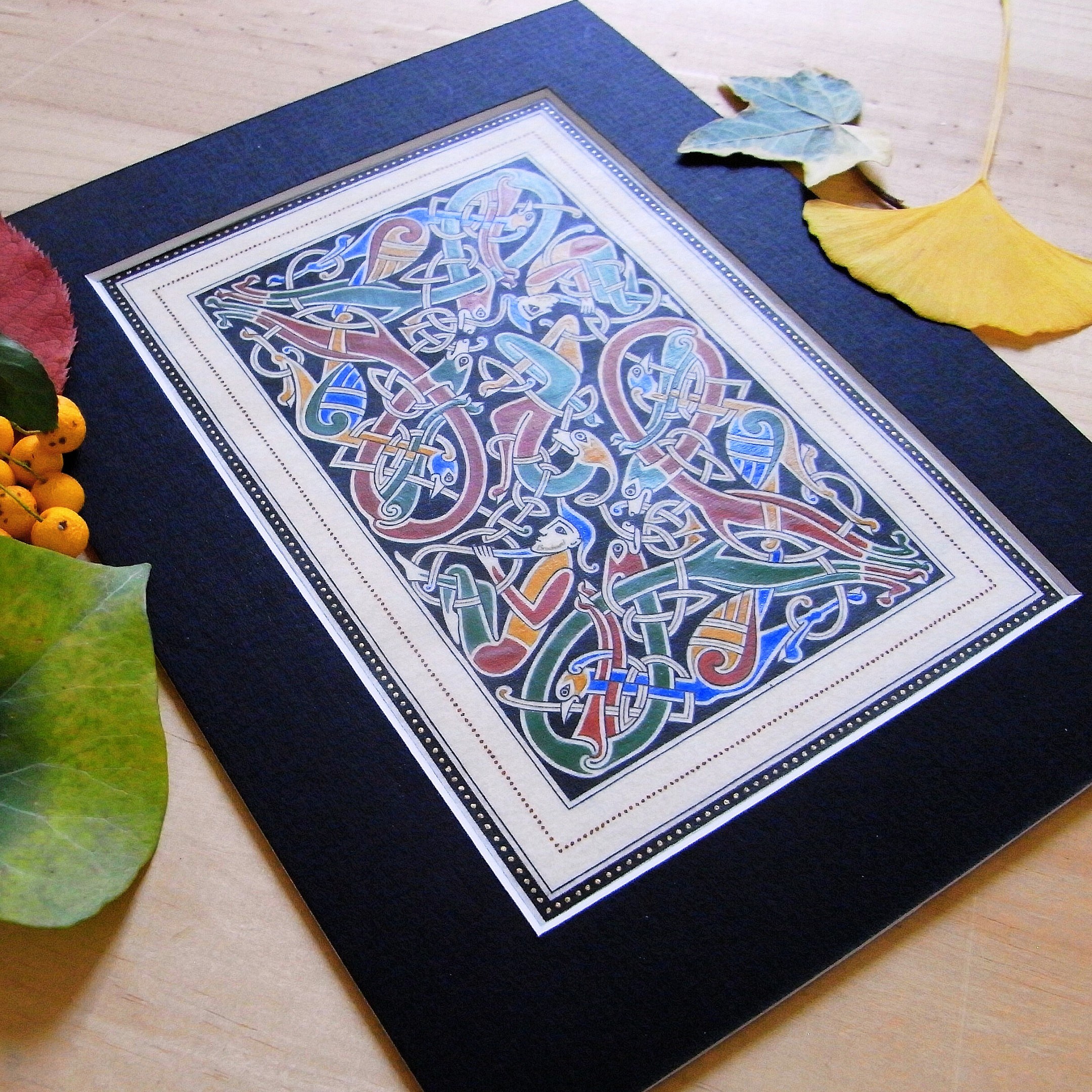 Enluminure insulaire avec entrelacs zoomorphes sur fond noir.