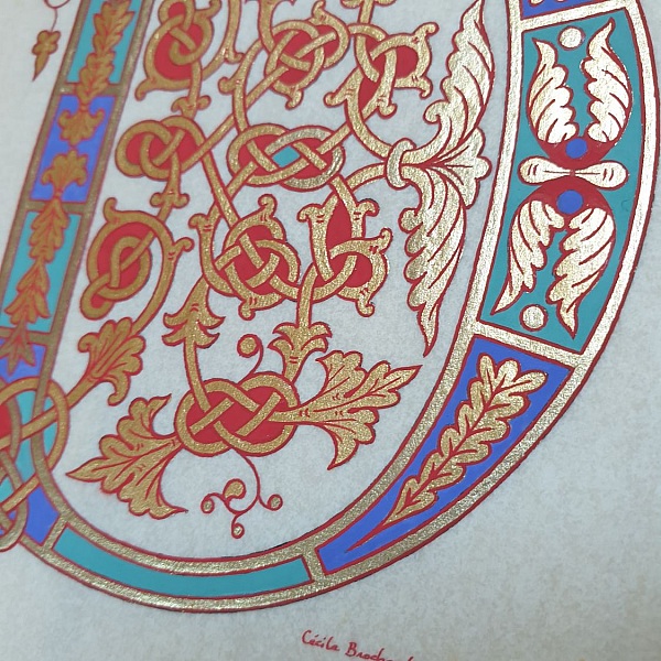 Lettre enluminée médiévale aux motifs dorés et végétaux.